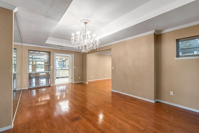 3547 W Locust Ave, Fresno, CA 93711 - unfurnished room featuring wood finished floors, a chandelier, a raised ceiling, and crown molding