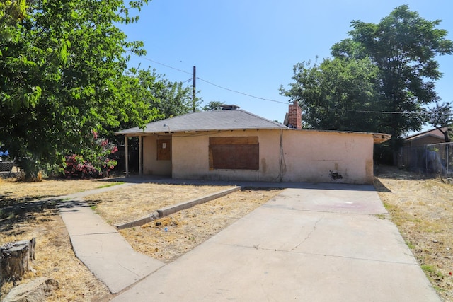 2413 S Sierra Vista Ave, Fresno, CA 93725 - view of front of property with stucco siding, a chimney, and a patio