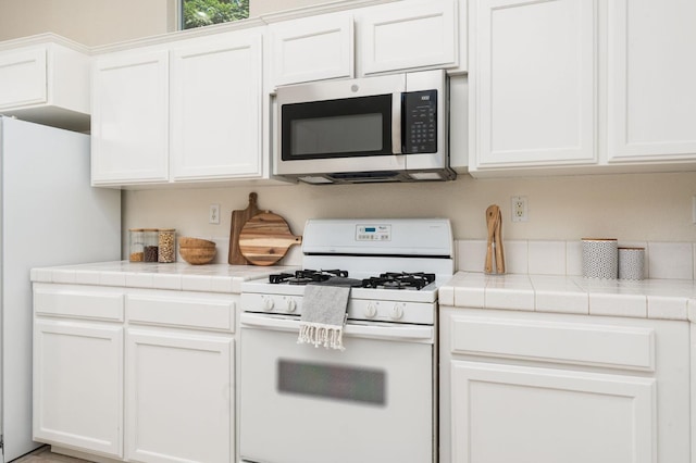 9416 N Jade Ave, Fresno, CA 93720 - kitchen with white appliances, white cabinetry, and tile countertops