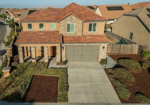 463 Mesa Dr S, Madera, CA 93636 - mediterranean / spanish home with stone siding, a tile roof, covered porch, concrete driveway, and a garage