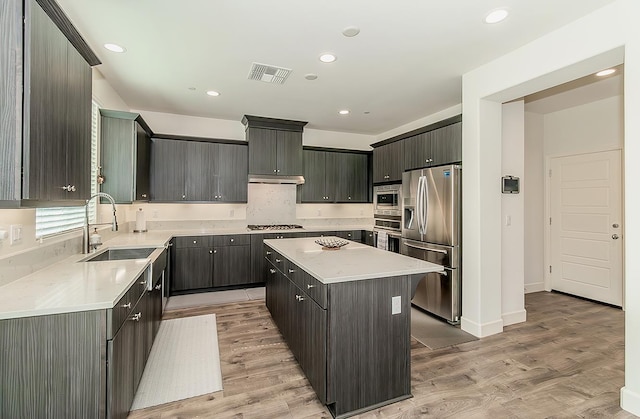 463 Mesa Dr S, Madera, CA 93636 - kitchen with appliances with stainless steel finishes, a kitchen island, light countertops, light wood-type flooring, and recessed lighting