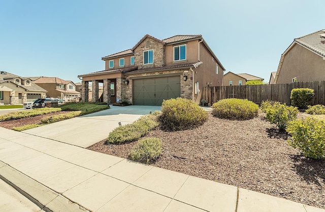 463 Mesa Dr S, Madera, CA 93636 - view of front of property featuring stone siding, driveway, an attached garage, a tiled roof, and stucco siding