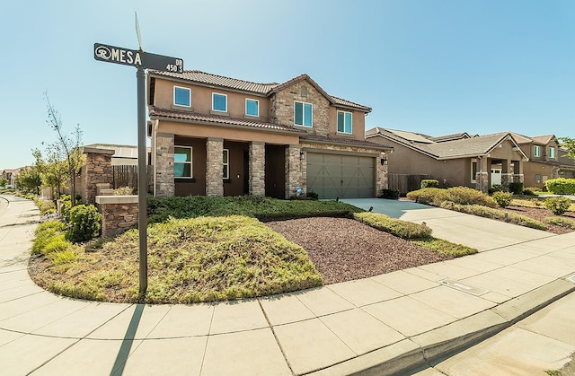 463 Mesa Dr S, Madera, CA 93636 - view of front facade featuring stone siding, driveway, an attached garage, a tiled roof, and stucco siding