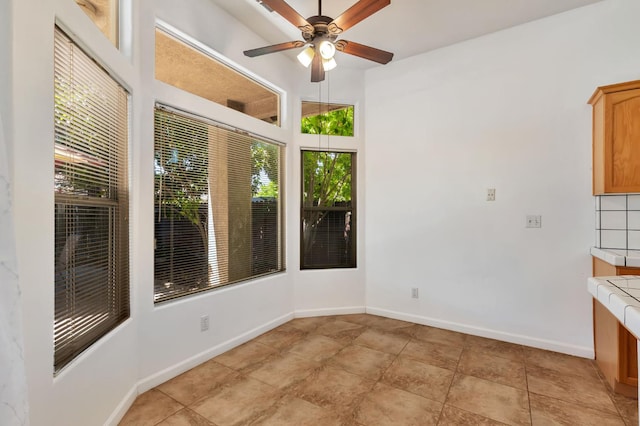 5613 W Bluff Ave, Fresno, CA 93722 - unfurnished dining area featuring ceiling fan and light tile patterned floors