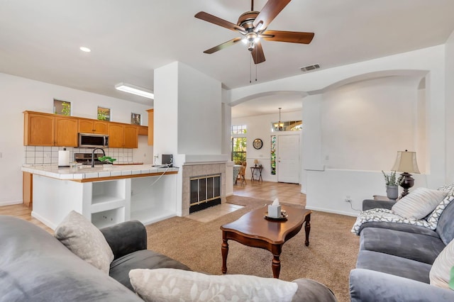 5613 W Bluff Ave, Fresno, CA 93722 - living room with arched walkways, a ceiling fan, recessed lighting, and light colored carpet