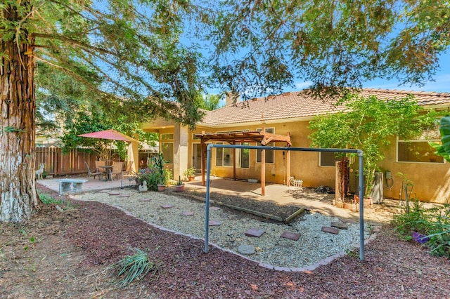 5613 W Bluff Ave, Fresno, CA 93722 - rear view of house featuring a pergola, a tile roof, a patio area, stucco siding, and a chimney