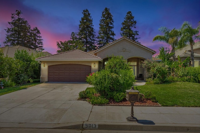 5613 W Bluff Ave, Fresno, CA 93722 - mediterranean / spanish-style house with stucco siding, a garage, a tile roof, a front lawn, and concrete driveway