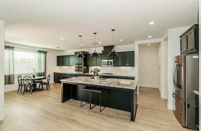 117 Emperor Way, Dinuba, CA 93618 - kitchen with appliances with stainless steel finishes, light stone counters, decorative backsplash, light wood-type flooring, and recessed lighting