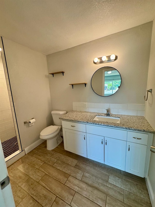195 Hoover St, Coalinga, CA 93210 - bathroom featuring vanity, a textured ceiling, tiled shower, and wood finish floors