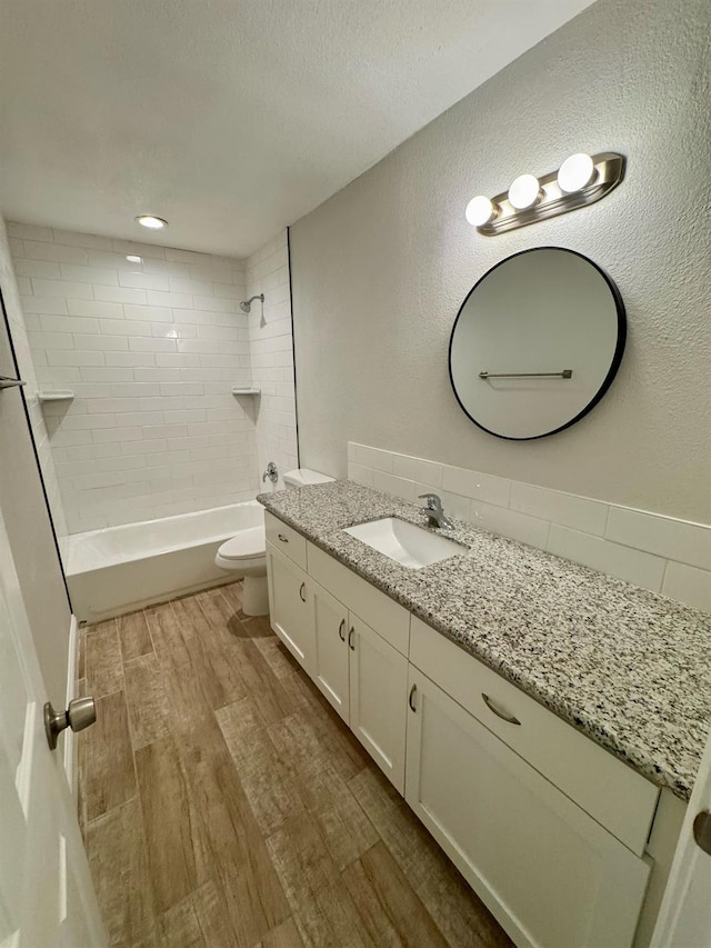195 Hoover St, Coalinga, CA 93210 - full bath with wood finished floors, vanity, shower / washtub combination, a textured wall, and a textured ceiling