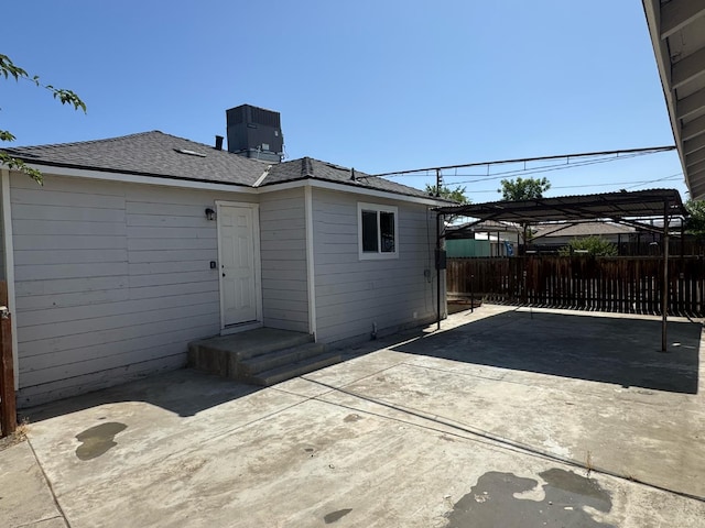 195 Hoover St, Coalinga, CA 93210 - back of property featuring a carport, roof with shingles, and a patio