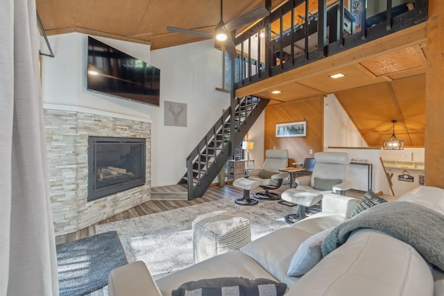 40607 Mill Run Ln Unit 72, Shaver Lake, CA 93664 - living area with wood finished floors, a stone fireplace, stairway, a ceiling fan, and wood walls