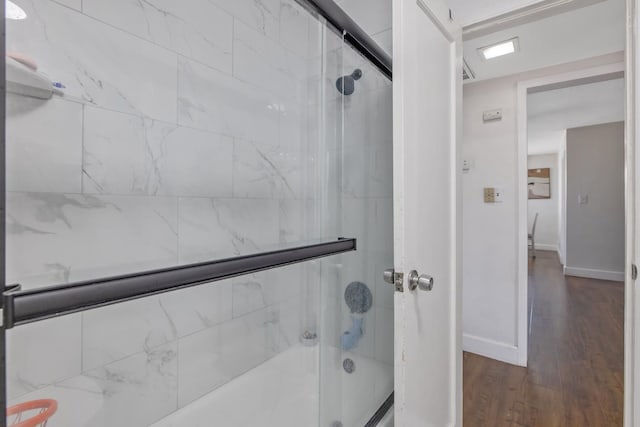 723 N Lourae Ave, Reedley, CA 93654 - bathroom featuring shower / bath combination with glass door and wood finished floors