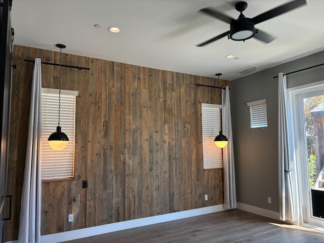 4240 Rall Ave, Clovis, CA 93619 - spare room with wooden walls, wood finished floors, recessed lighting, ceiling fan, and a barn door