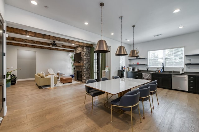 4240 Rall Ave, Clovis, CA 93619 - dining area with light wood-style flooring, a stone fireplace, bar with sink, recessed lighting, and a ceiling fan