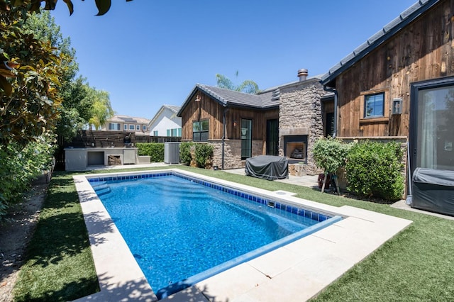 4240 Rall Ave, Clovis, CA 93619 - view of swimming pool featuring an outdoor kitchen, a patio area, and an outdoor stone fireplace