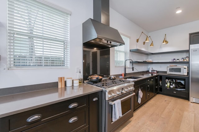 4240 Rall Ave, Clovis, CA 93619 - kitchen with stainless steel appliances, wall chimney range hood, light wood-style flooring, and open shelves