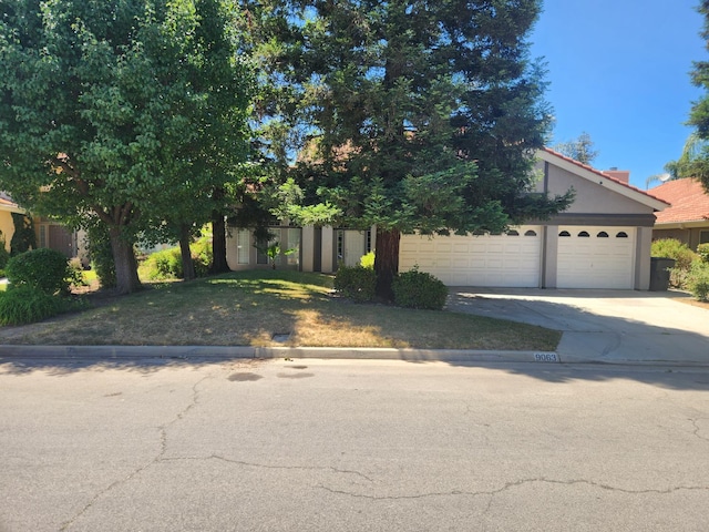 9063 N Woodrow Ave, Fresno, CA 93720 - obstructed view of property featuring driveway, stucco siding, and a garage
