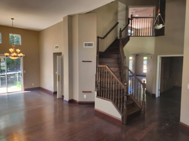 9063 N Woodrow Ave, Fresno, CA 93720 - unfurnished living room with a high ceiling, a chandelier, wood finished floors, and stairway