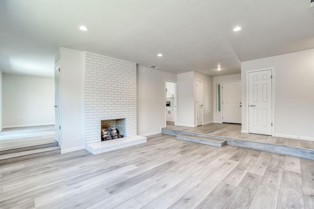 5276 N 1st St, Fresno, CA 93710 - unfurnished living room featuring light wood finished floors, a brick fireplace, and recessed lighting