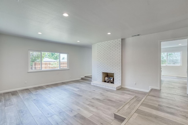 5276 N 1st St, Fresno, CA 93710 - unfurnished living room featuring light wood-type flooring, recessed lighting, and a brick fireplace