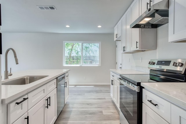 5276 N 1st St, Fresno, CA 93710 - kitchen featuring appliances with stainless steel finishes, range hood, light wood finished floors, white cabinets, and recessed lighting