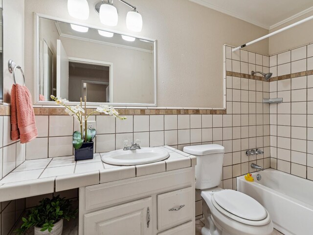 3672 N Shirley Ave, Fresno, CA 93727 - bathroom featuring vanity, ornamental molding, bathtub / shower combination, and tile walls