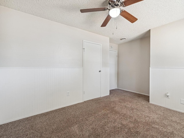 3672 N Shirley Ave, Fresno, CA 93727 - carpeted empty room featuring a textured ceiling, wainscoting, and a ceiling fan