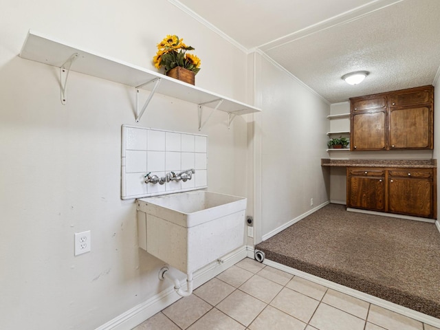 3672 N Shirley Ave, Fresno, CA 93727 - laundry room featuring ornamental molding, light tile patterned flooring, a textured ceiling, and light carpet