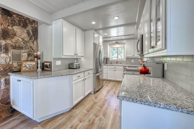 42198 Smoke Tree, Shaver Lake, CA 93664 - kitchen with appliances with stainless steel finishes, light wood-style flooring, decorative backsplash, white cabinets, and light stone countertops