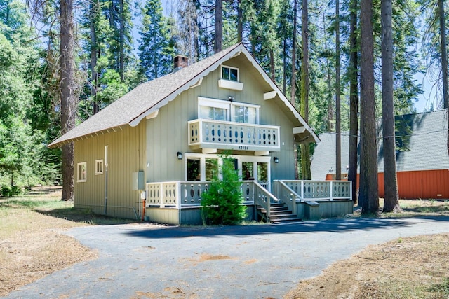 42198 Smoke Tree, Shaver Lake, CA 93664 - view of front of home with a shingled roof, a chimney, asphalt driveway, and a balcony