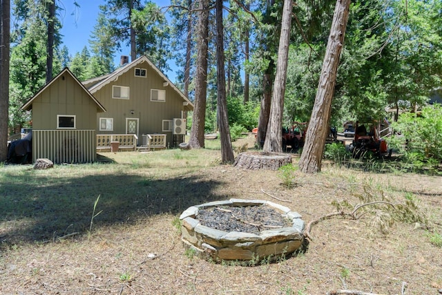 42198 Smoke Tree, Shaver Lake, CA 93664 - rear view of house with a fire pit, a wooden deck, and board and batten siding
