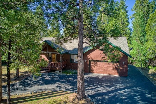 42052 Granite Ridge Rd, Shaver Lake, CA 93664 - rustic home featuring driveway, a wooden deck, an attached garage, and roof with shingles