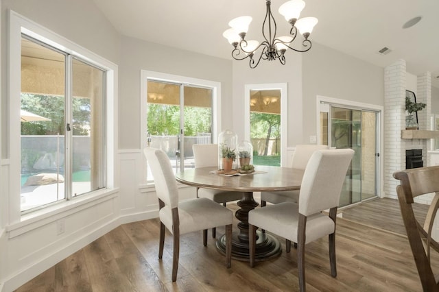 7671 N Ricewood Ave, Fresno, CA 93711 - dining room with wood finished floors, a chandelier, vaulted ceiling, and a wainscoted wall