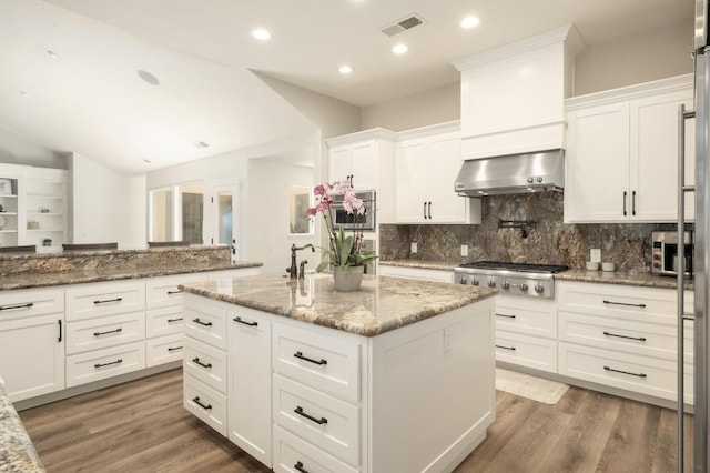 7671 N Ricewood Ave, Fresno, CA 93711 - kitchen with stainless steel gas stovetop, extractor fan, white cabinets, backsplash, and a kitchen island with sink