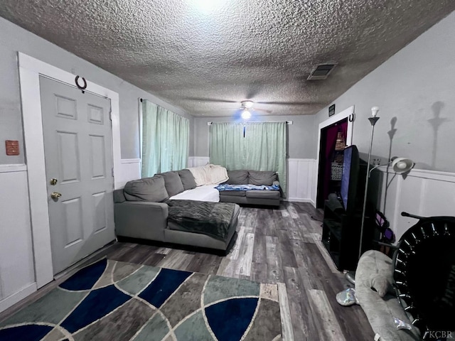 420 E Florinda St, Hanford, CA 93230 - living room featuring wood finished floors, a textured ceiling, wainscoting, a ceiling fan, and a decorative wall