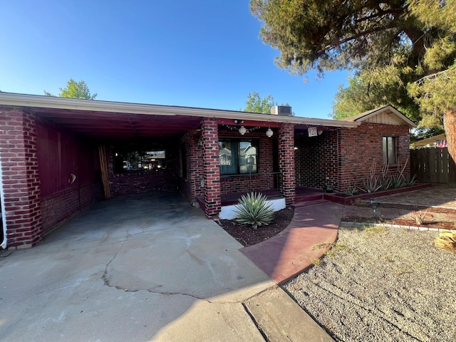420 E Florinda St, Hanford, CA 93230 - ranch-style house featuring brick siding, a porch, concrete driveway, and an attached carport