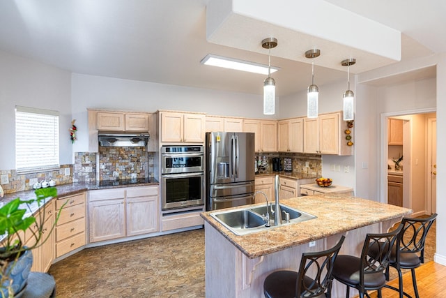 2322 E Revere Rd, Fresno, CA 93720 - kitchen featuring stainless steel appliances, light brown cabinetry, tasteful backsplash, under cabinet range hood, and a breakfast bar area