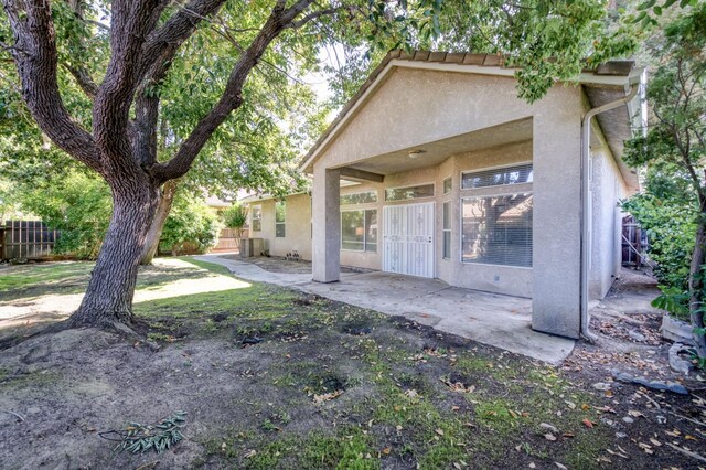 7515 N Wheeler Ave, Fresno, CA 93722 - rear view of property with stucco siding and a patio area