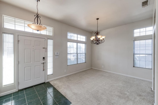 7515 N Wheeler Ave, Fresno, CA 93722 - entrance foyer featuring a chandelier, dark tile patterned flooring, and dark colored carpet