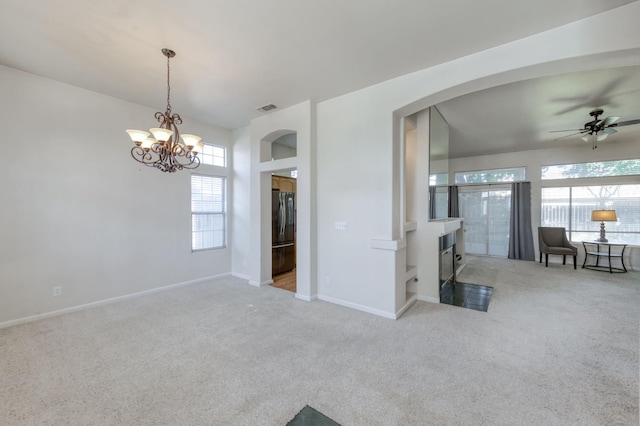 7515 N Wheeler Ave, Fresno, CA 93722 - carpeted empty room with a chandelier, arched walkways, and ceiling fan