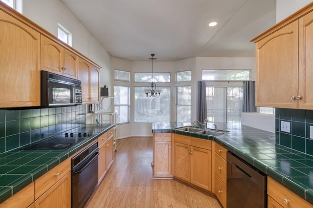 7515 N Wheeler Ave, Fresno, CA 93722 - kitchen with black appliances, tile countertops, light wood-style flooring, plenty of natural light, and recessed lighting