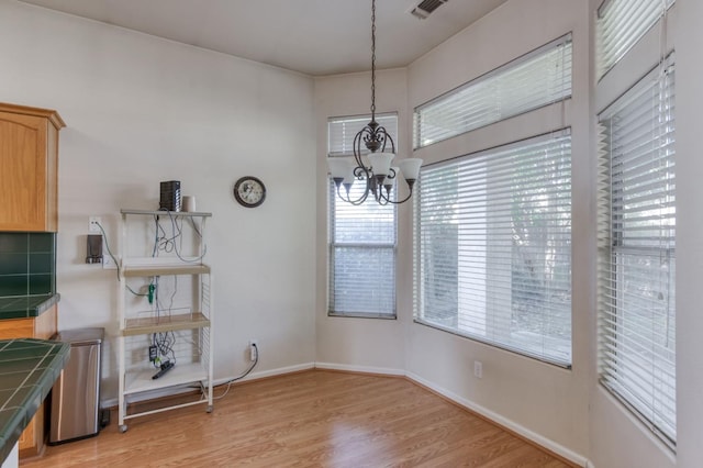 7515 N Wheeler Ave, Fresno, CA 93722 - unfurnished dining area featuring a chandelier and light wood-style floors