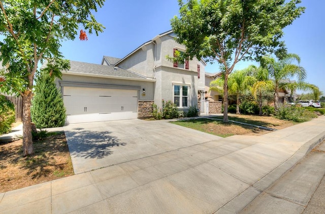 3669 N Clover Ave, Fresno, CA 93727 - view of front of property featuring stucco siding, concrete driveway, an attached garage, and stone siding
