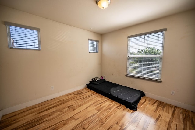 3669 N Clover Ave, Fresno, CA 93727 - unfurnished bedroom with multiple windows and wood finished floors