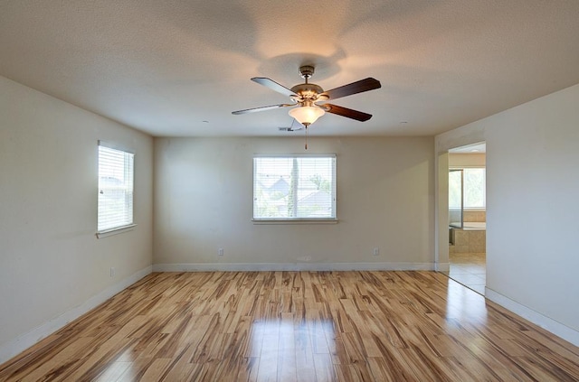 3669 N Clover Ave, Fresno, CA 93727 - empty room featuring plenty of natural light, light wood finished floors, a ceiling fan, and a textured ceiling
