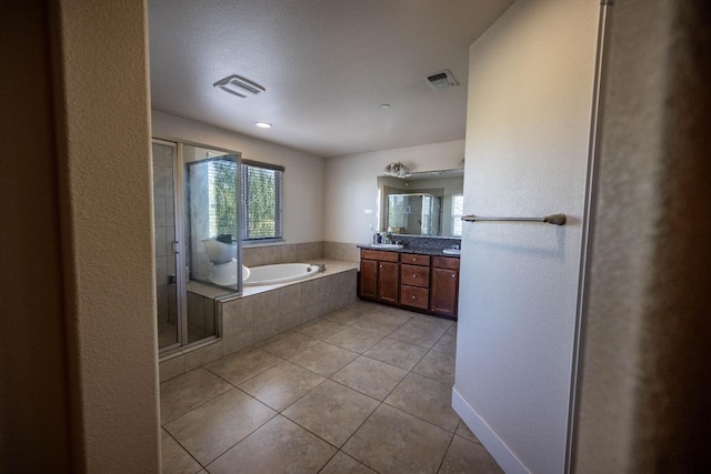 3669 N Clover Ave, Fresno, CA 93727 - bathroom featuring double vanity, tile patterned flooring, a garden tub, and a shower stall