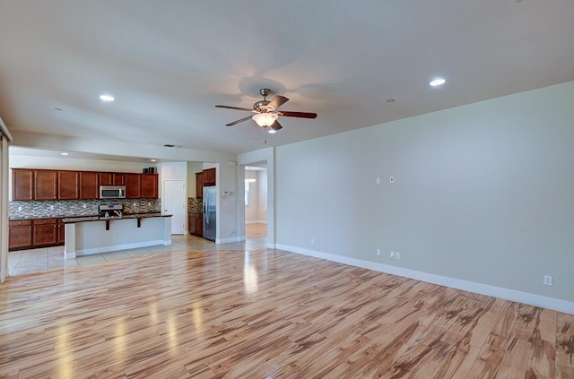 3669 N Clover Ave, Fresno, CA 93727 - unfurnished living room with light wood finished floors, ceiling fan, and recessed lighting