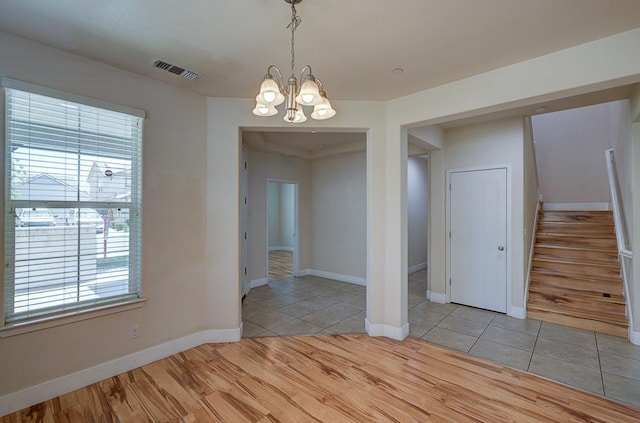 3669 N Clover Ave, Fresno, CA 93727 - unfurnished dining area featuring a chandelier, stairway, and light wood finished floors