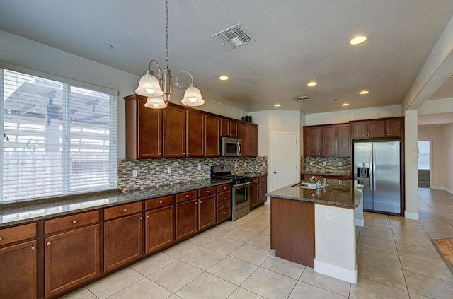 3669 N Clover Ave, Fresno, CA 93727 - kitchen featuring stainless steel appliances, backsplash, dark stone countertops, light tile patterned flooring, and recessed lighting